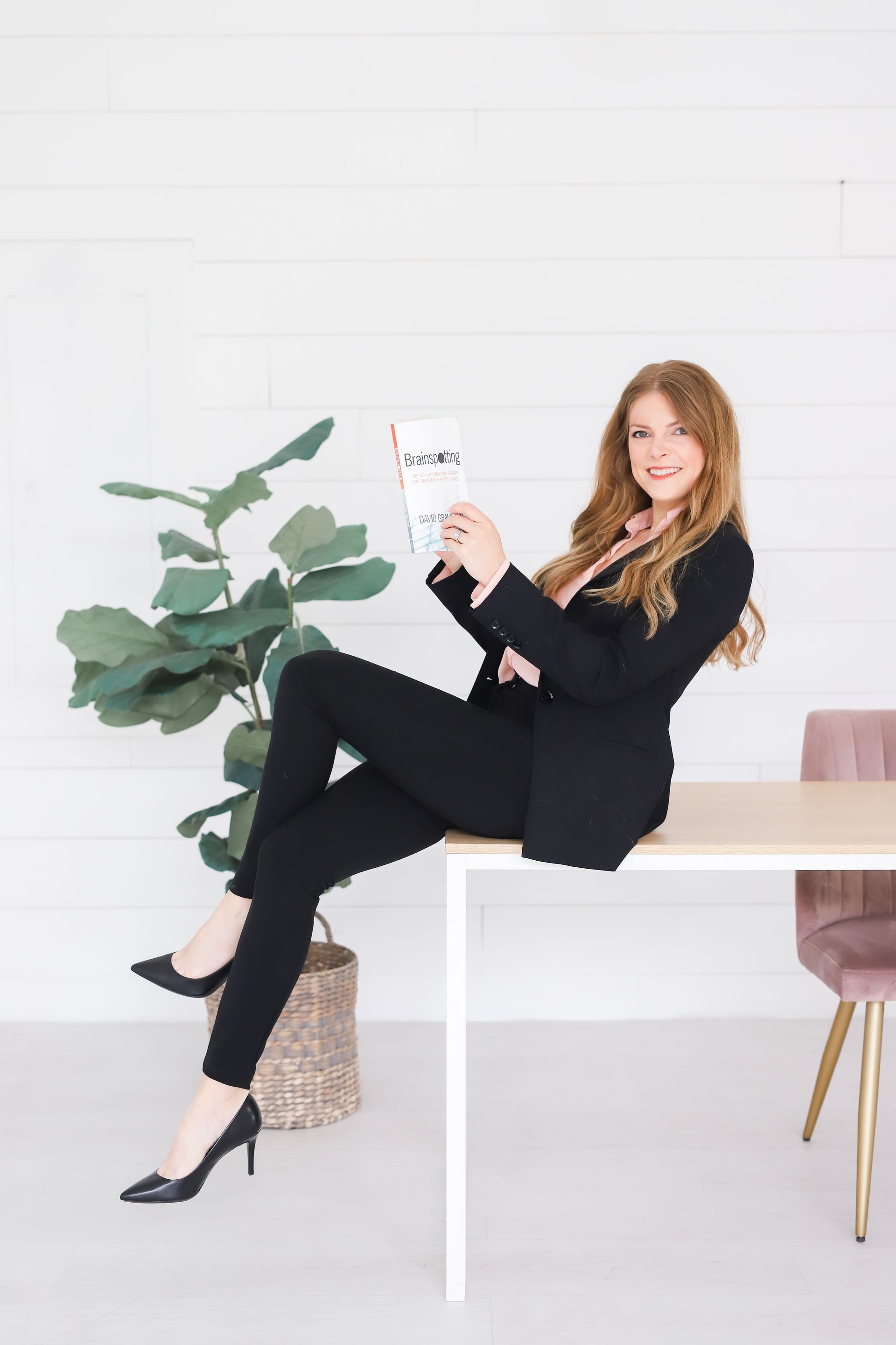 Cherie Spellman brainspotting consultant holding a brainspotting book sitting on a desk