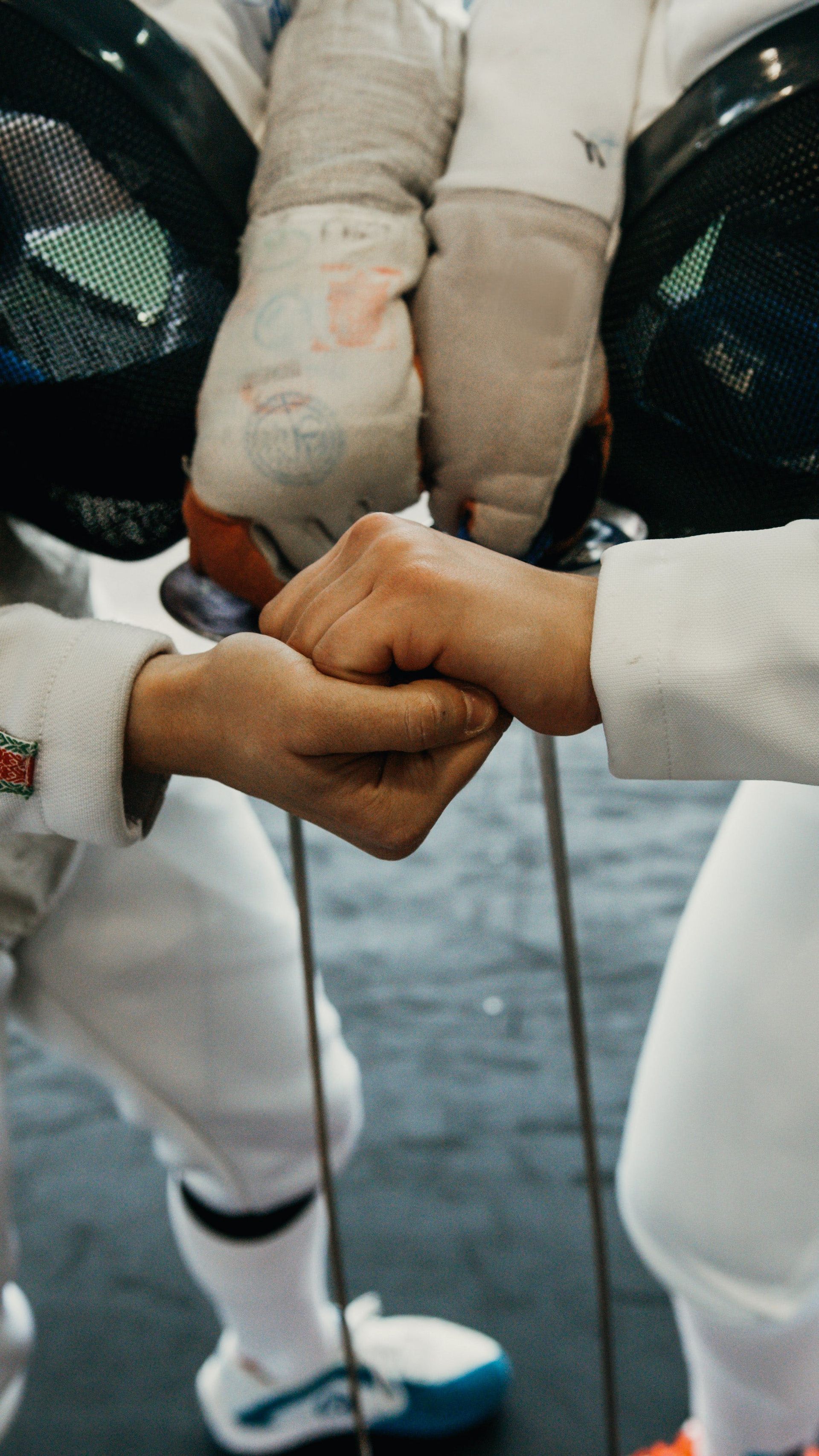 Two people are shaking hands while wearing fencing gloves in family counseling in DFW Texas