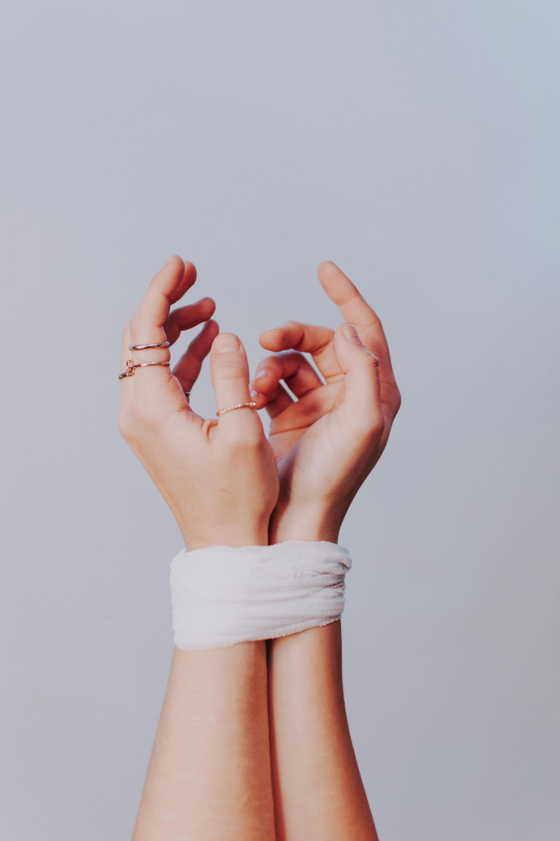 A woman 's hands are tied together with a bandage and rings representing trauma therapy in Grapevine Texas