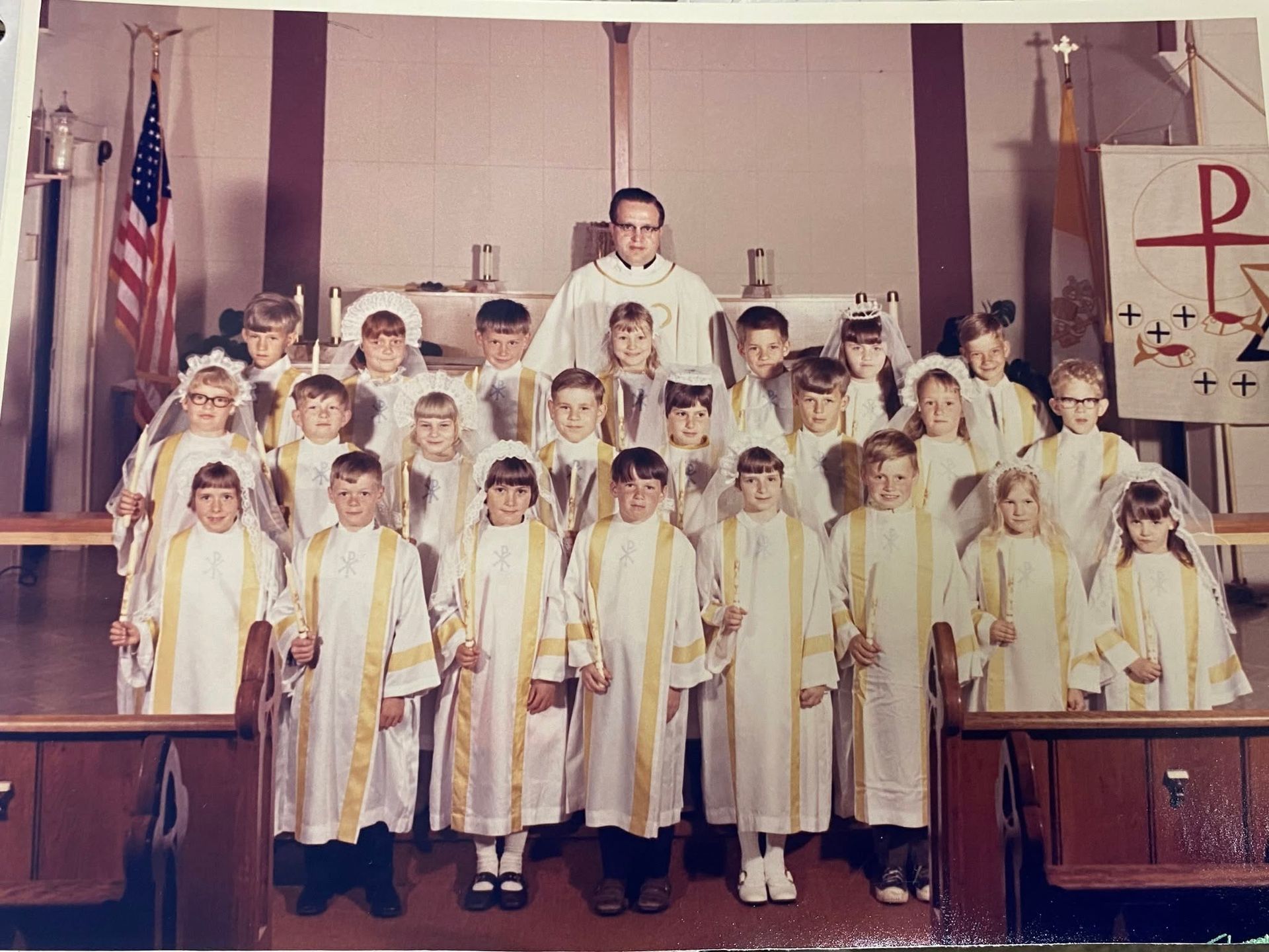 Choir in white robes with gold trim standing in a church sanctuary during a service