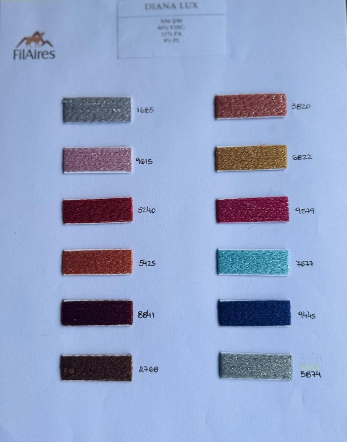 Muestras de color con texturas brillantes en varios tonos, dispuestas en filas sobre una superficie blanca.