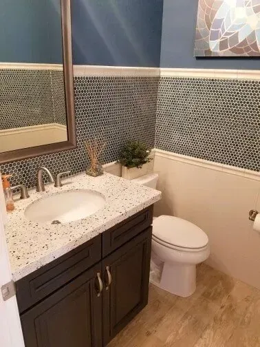 A bathroom with a sink , toilet and mirror.