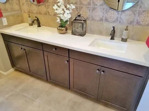 A bathroom vanity with two sinks and a mirror.