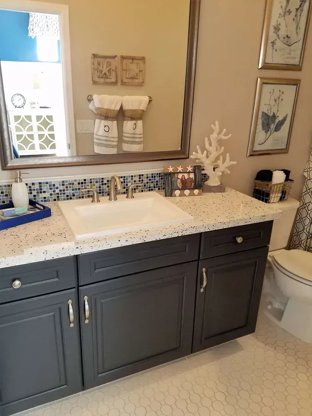 A bathroom with a sink , toilet and mirror.