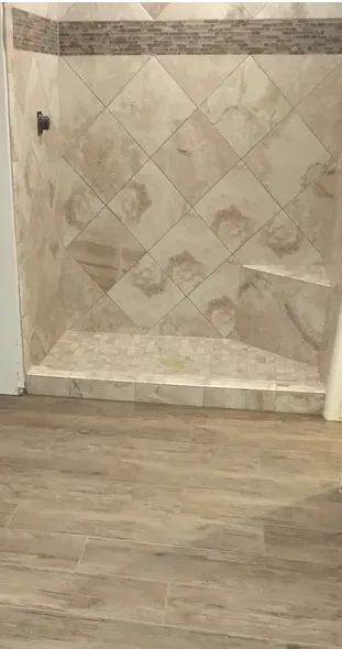 A bathroom with a walk in shower and a wooden floor.