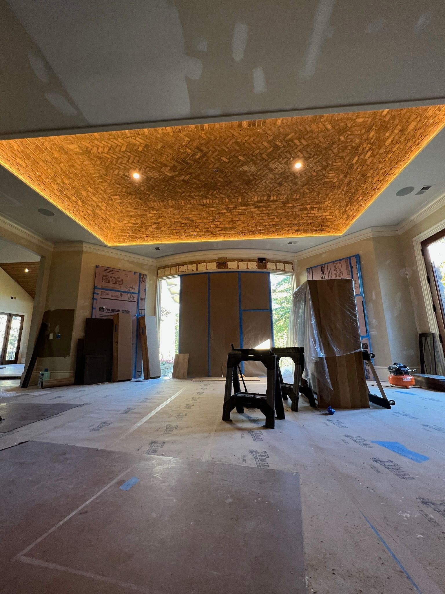 Renovation room with ornate orange ceiling, construction materials, and a small table near the center