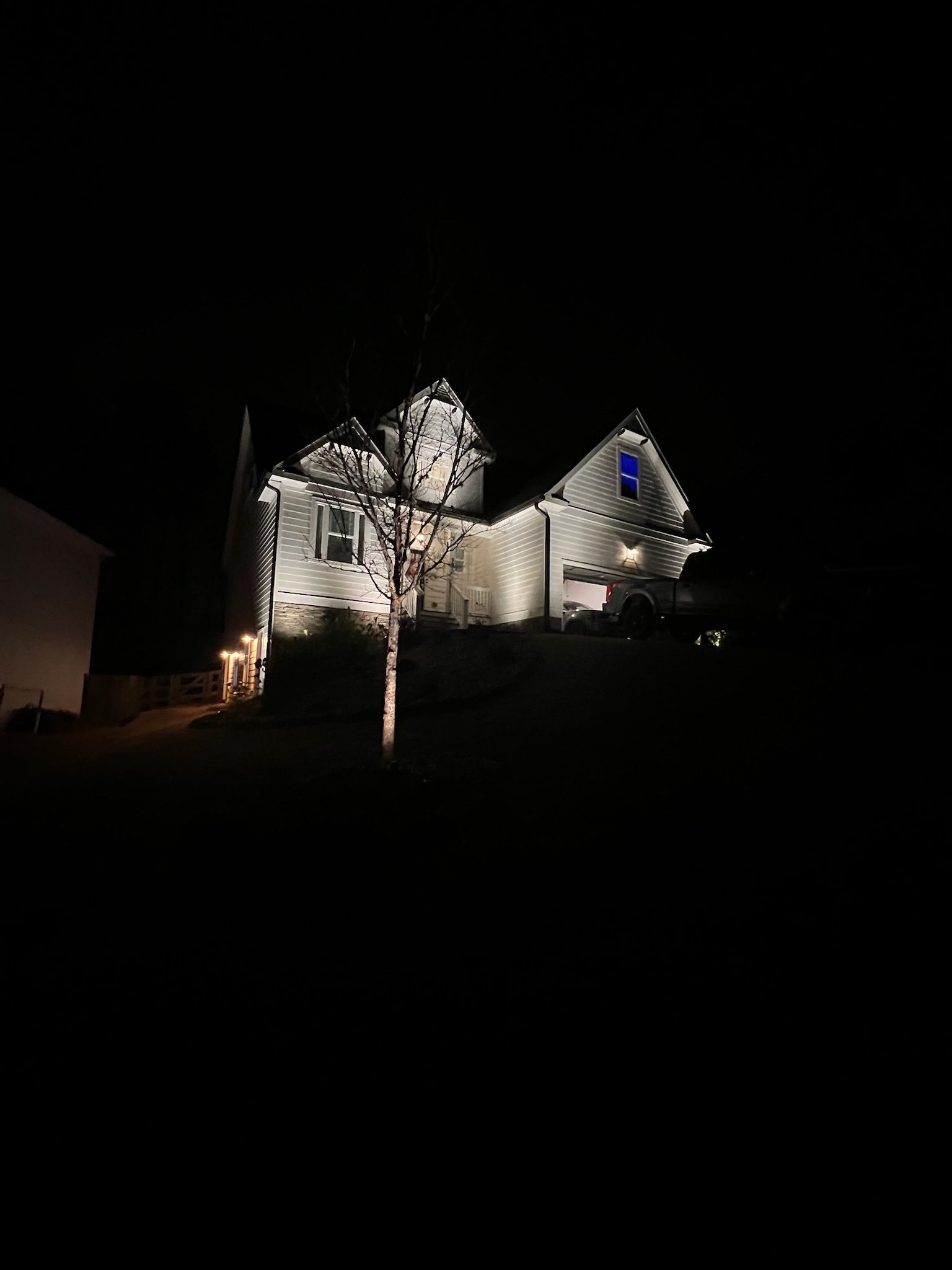 House lit up at night with trees and a dark sky around it