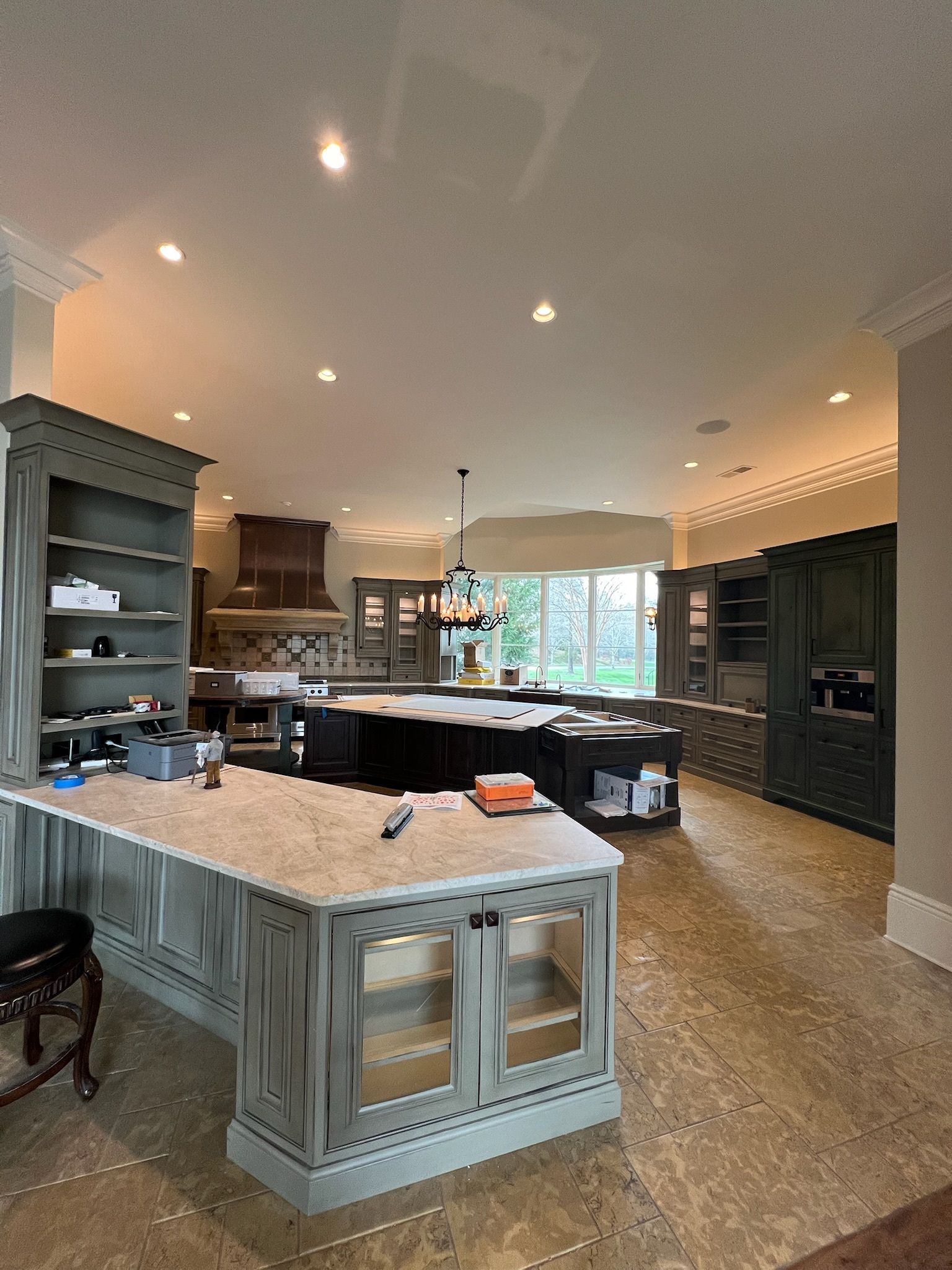 Spacious modern kitchen with a large island, dark cabinets, and warm recessed lighting