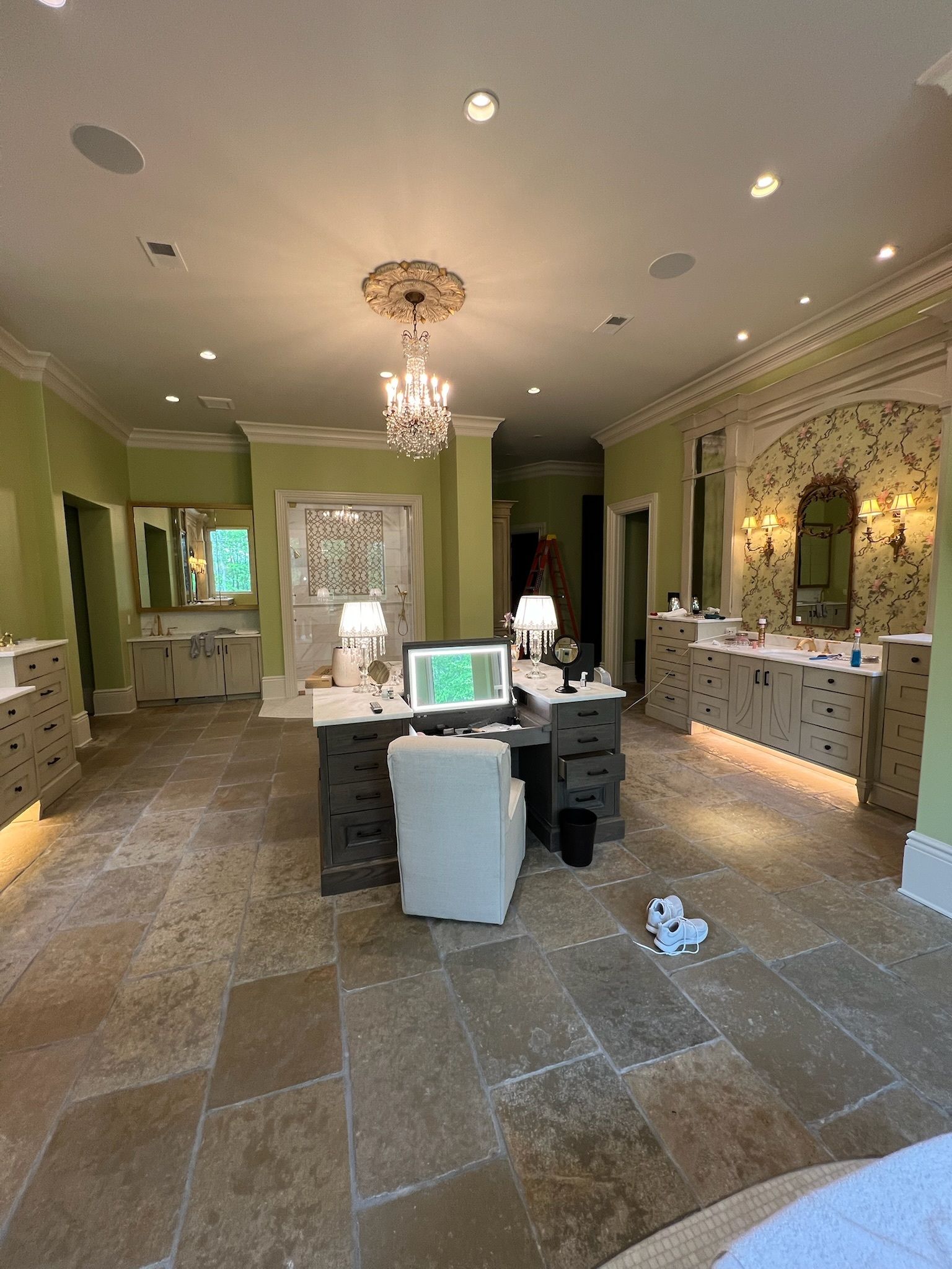 Elegant salon interior with chandeliers, ornate mirrors, manicure tables, and a tiled floor