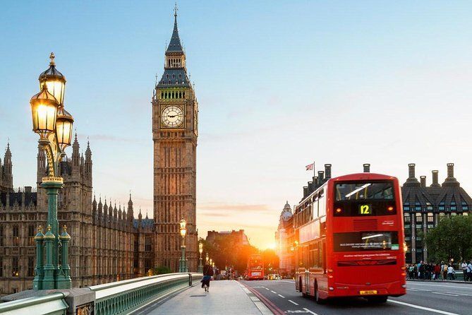 Red double-decker bus on Westminster Bridge with Big Ben at sunset in London