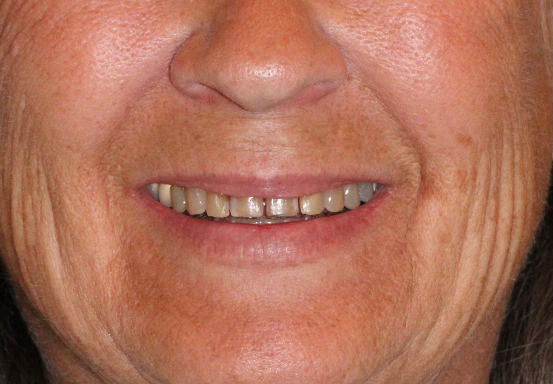 A close up of a woman 's face with a smile on her face.