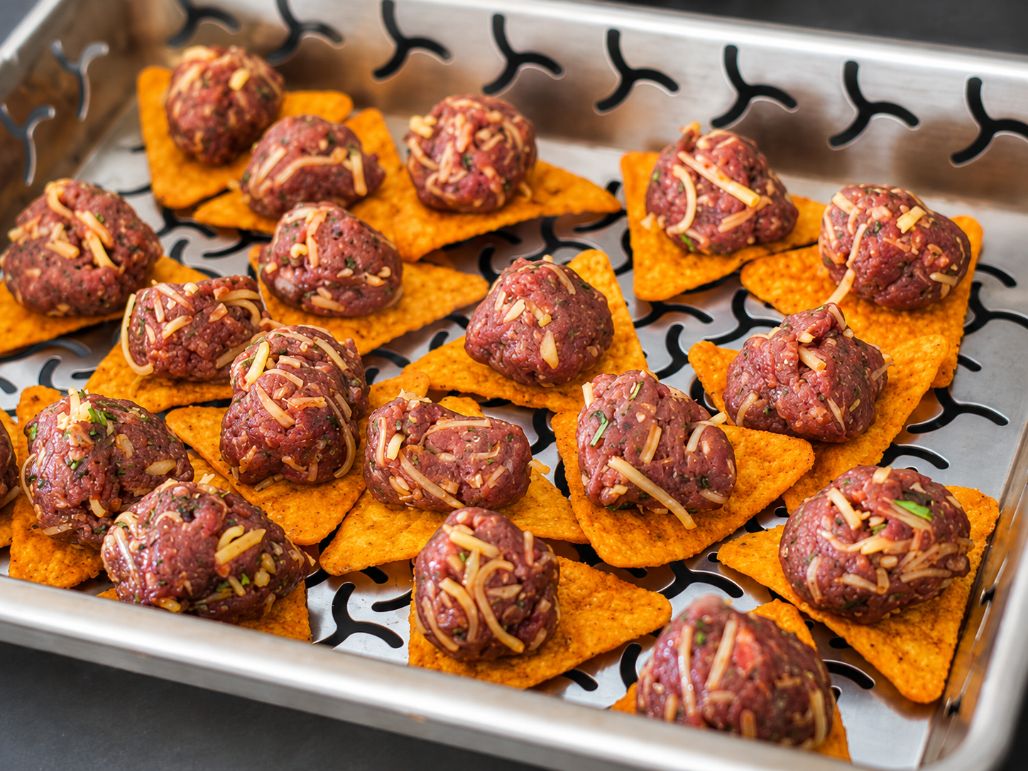 Rauwe Wagyu-gehaktballetjes met cheddar op nachochips in een barbecueschaal