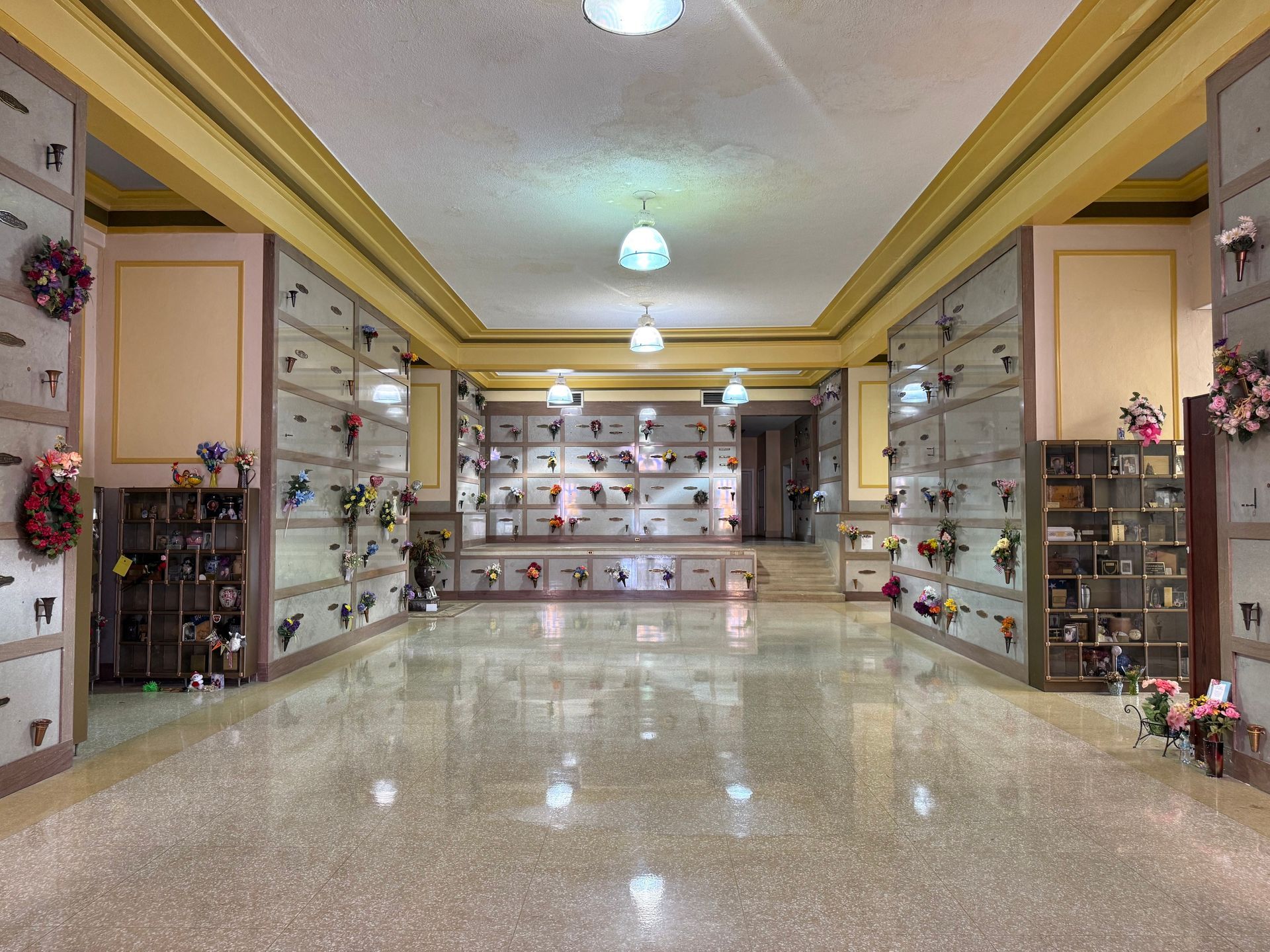 Bright hallway with polished floor and shelves of decorative items in a gallery or shop.