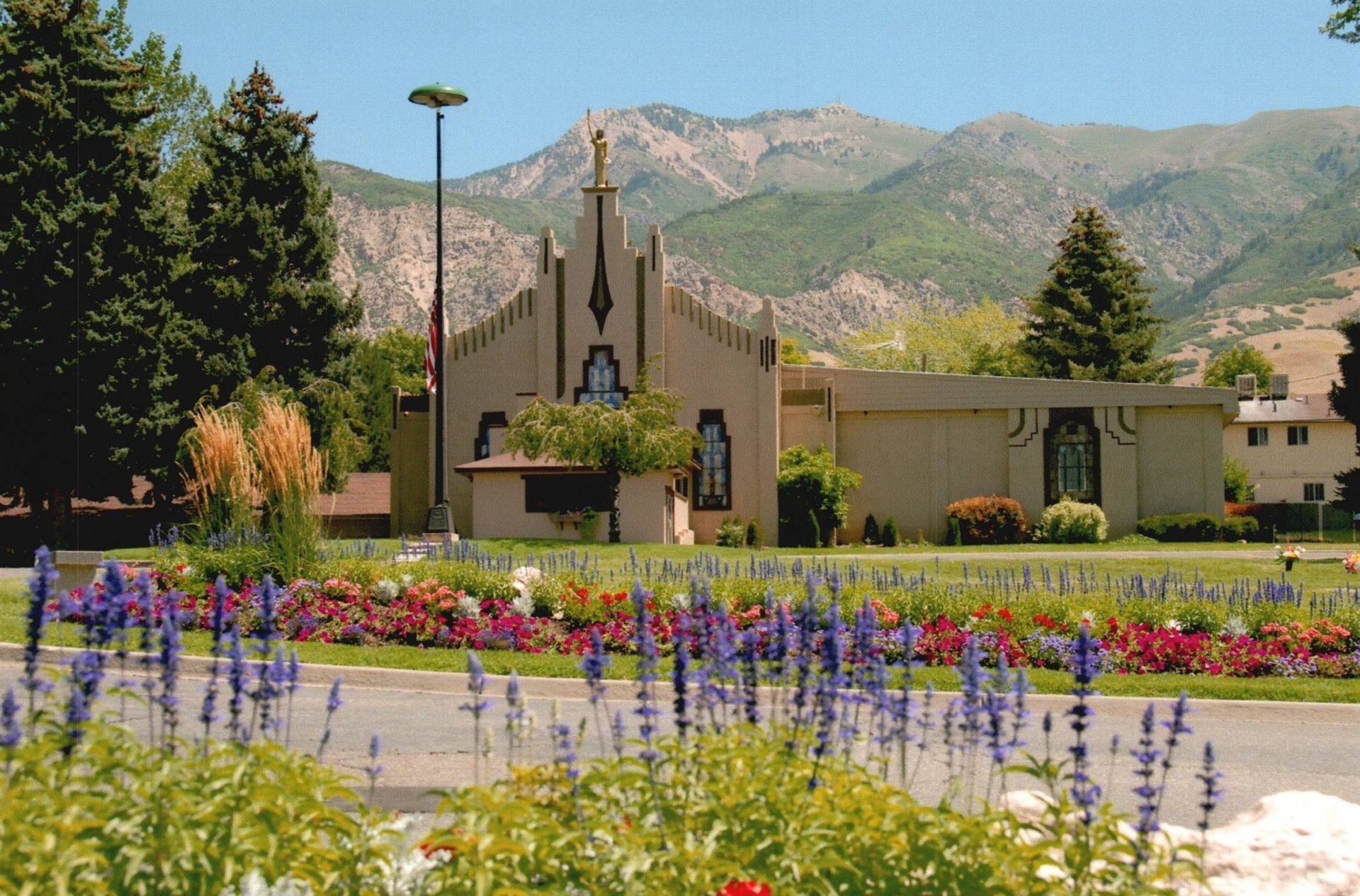 Colorful flower garden before a chapel with mountains in the background
