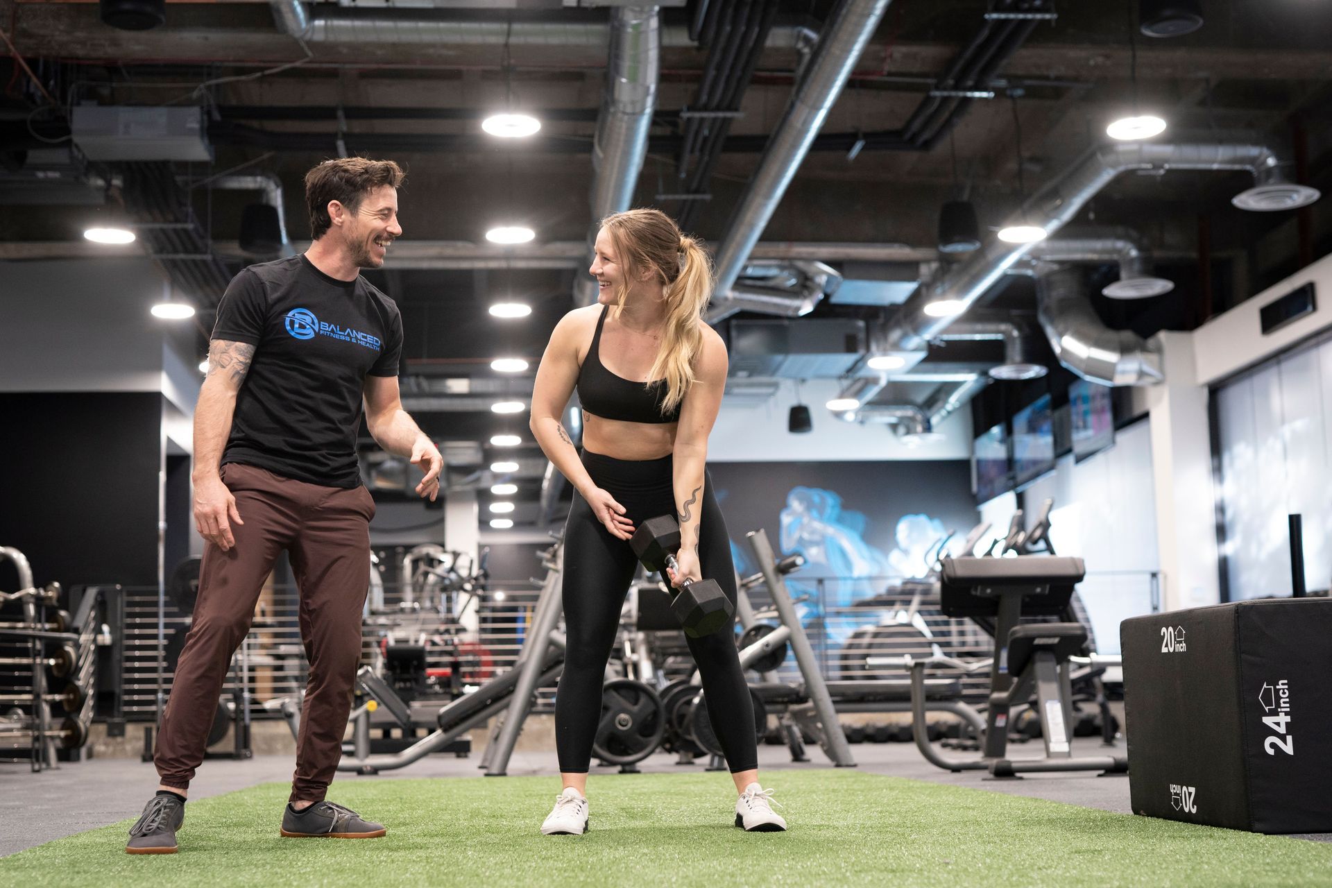 A man and a woman are standing next to each other in a gym.
