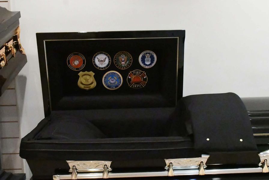 Open black presentation case with several military-style patches inside and gold clasps on the front