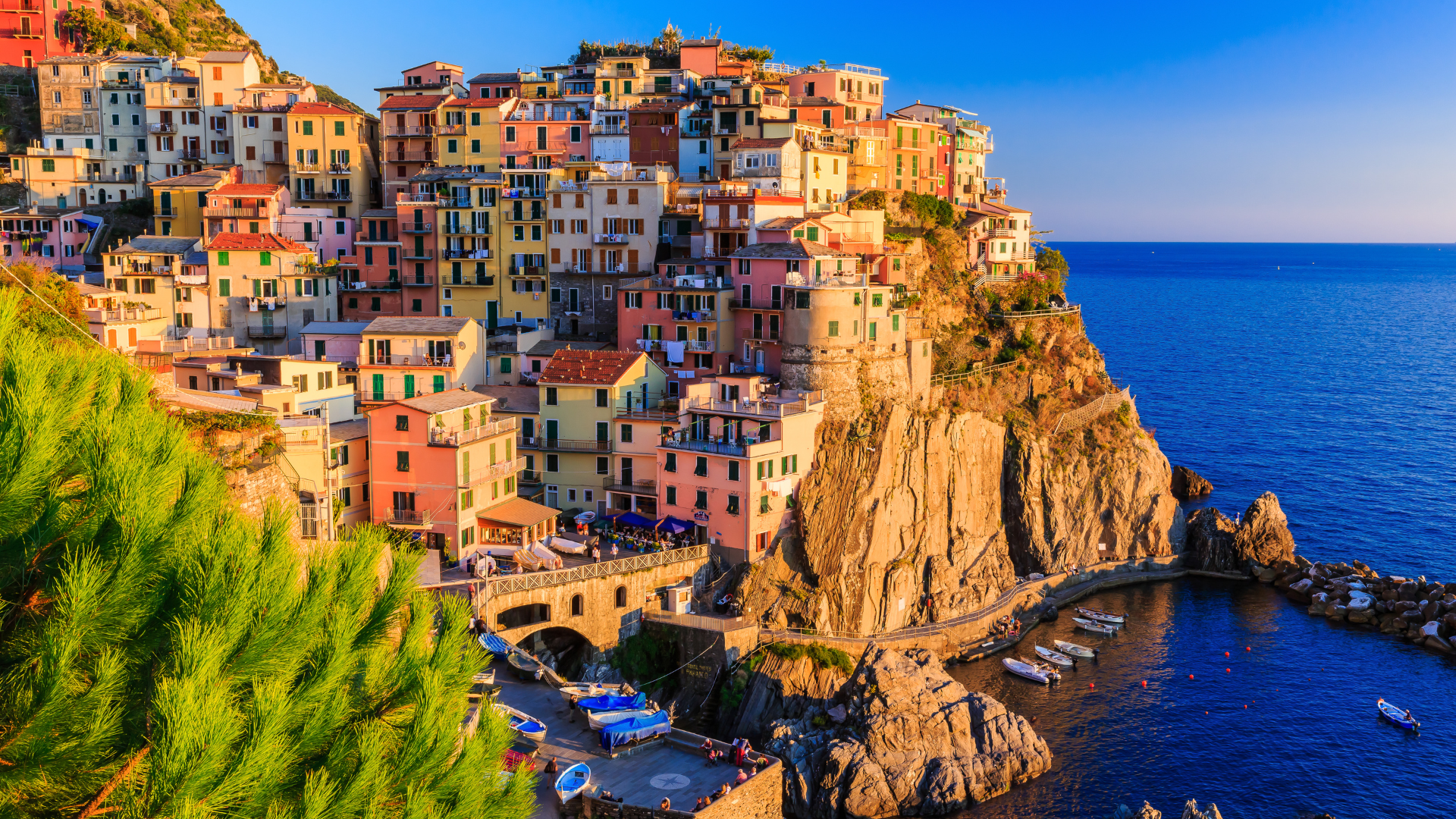 Colorful cliffside village overlooking a deep blue sea under a bright sky