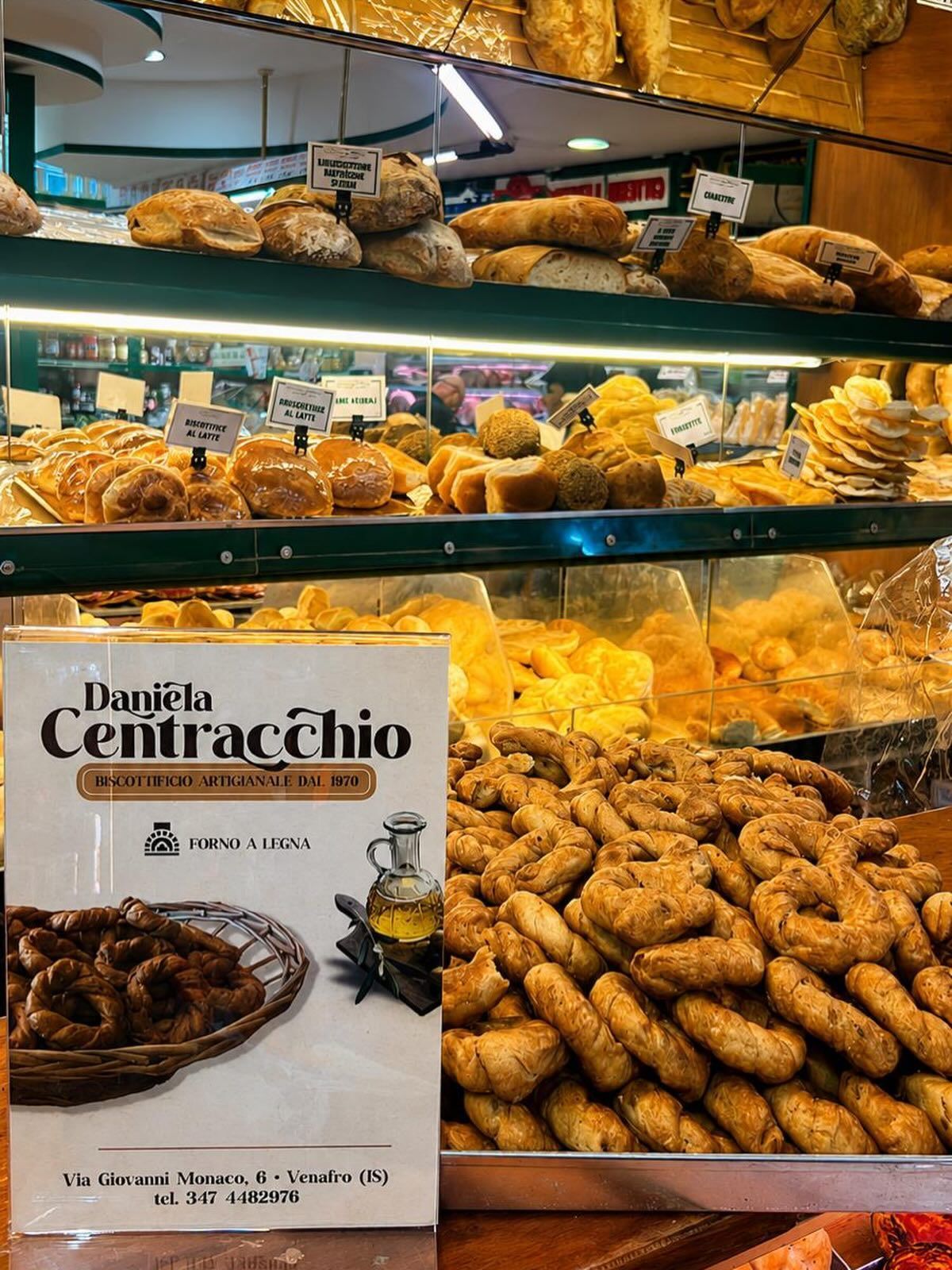 Vetrina di una pasticceria con vassoi di pasticcini fritti e l'insegna di Bignè Centracchio in primo piano.
