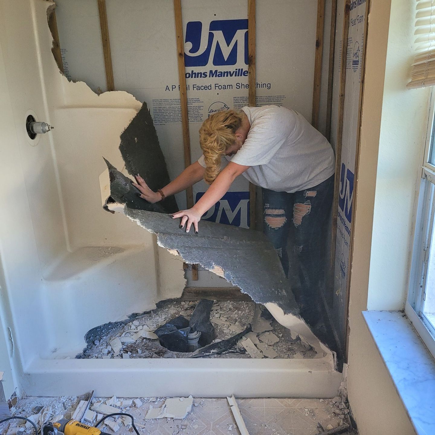 A woman is standing in a room with jm written on the wall