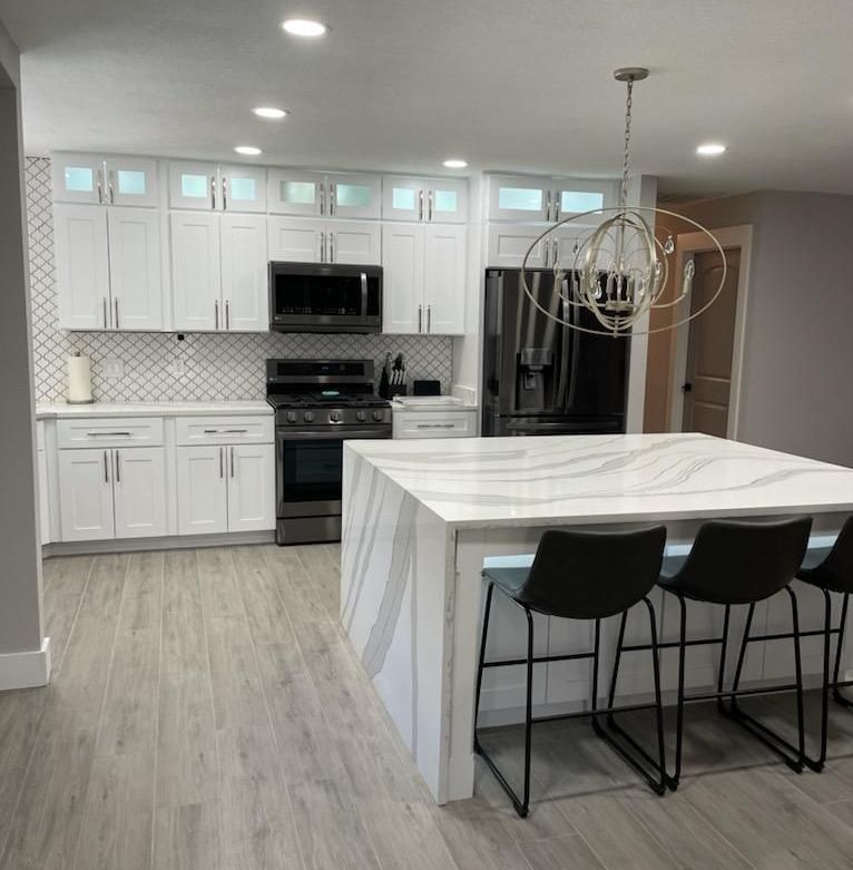 A kitchen with white cabinets and a large island