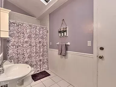 A bathroom with a sink , toilet and shower curtain.