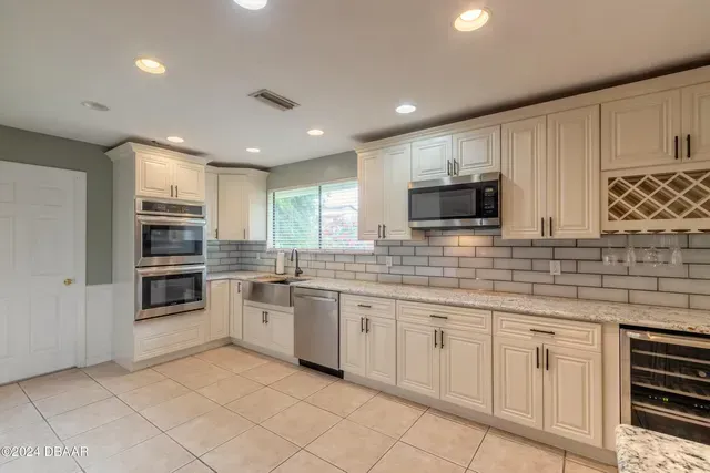 A kitchen with stainless steel appliances and white cabinets.