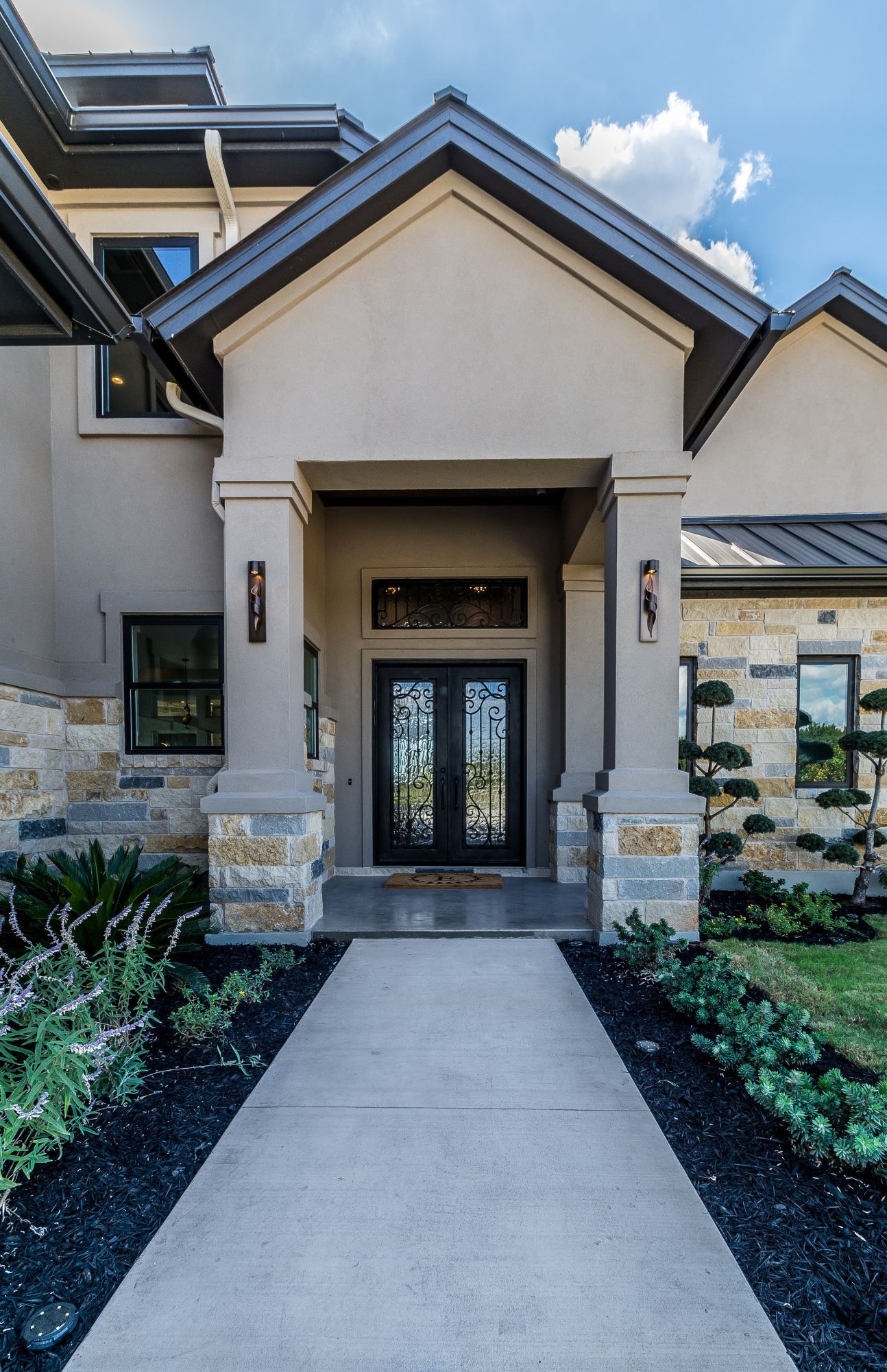 A large house with a walkway leading to the front door.