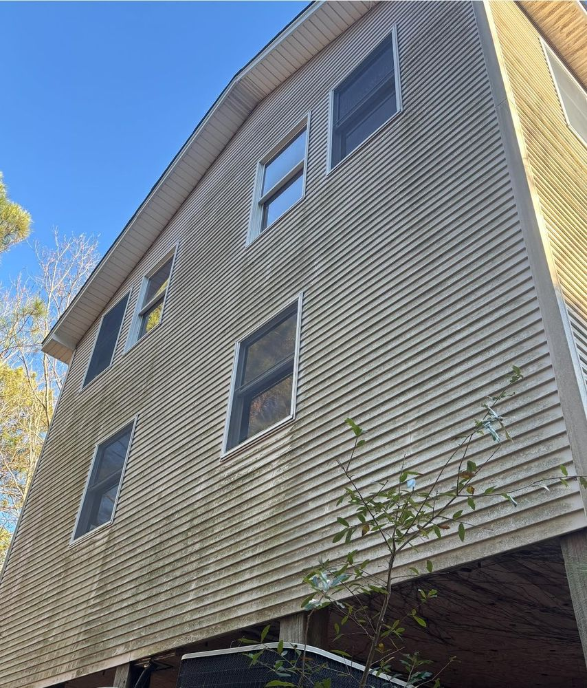 A house with a lot of windows and a blue sky in the background