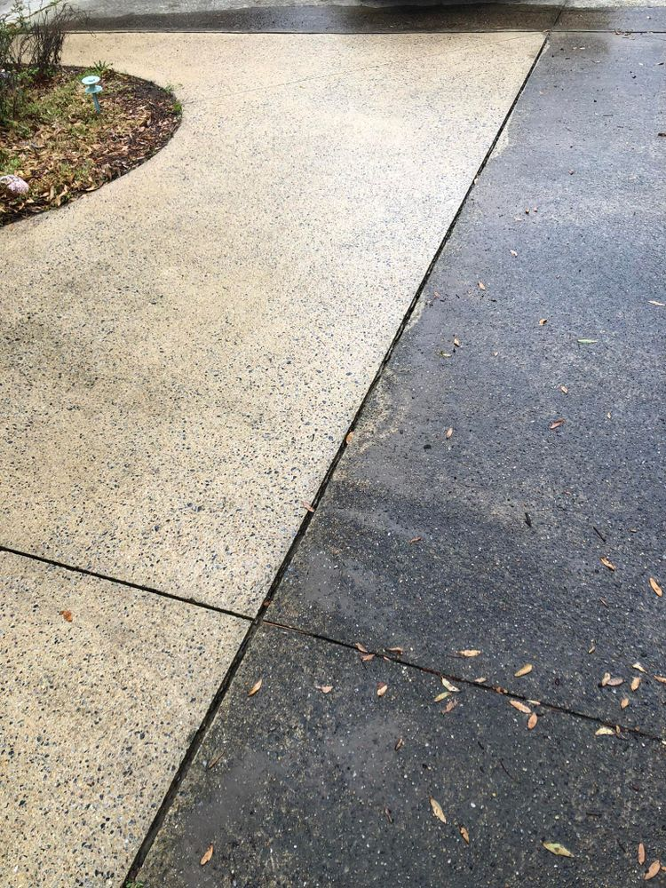 A concrete driveway with a few leaves on it.
