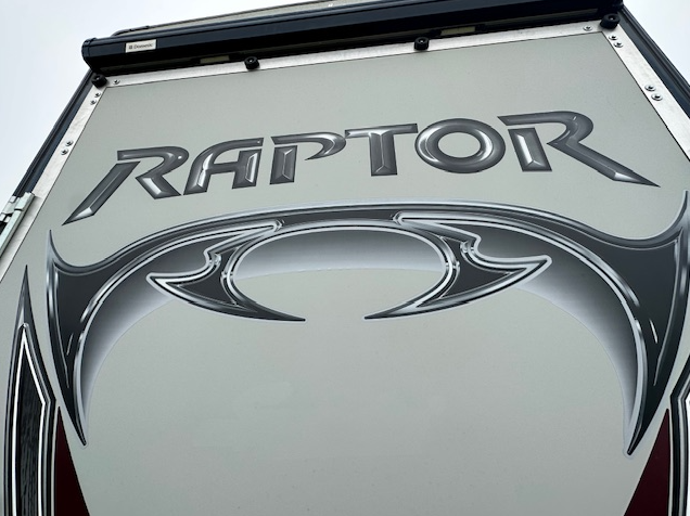 A close-up of a silver RV exterior featuring the black-and-silver