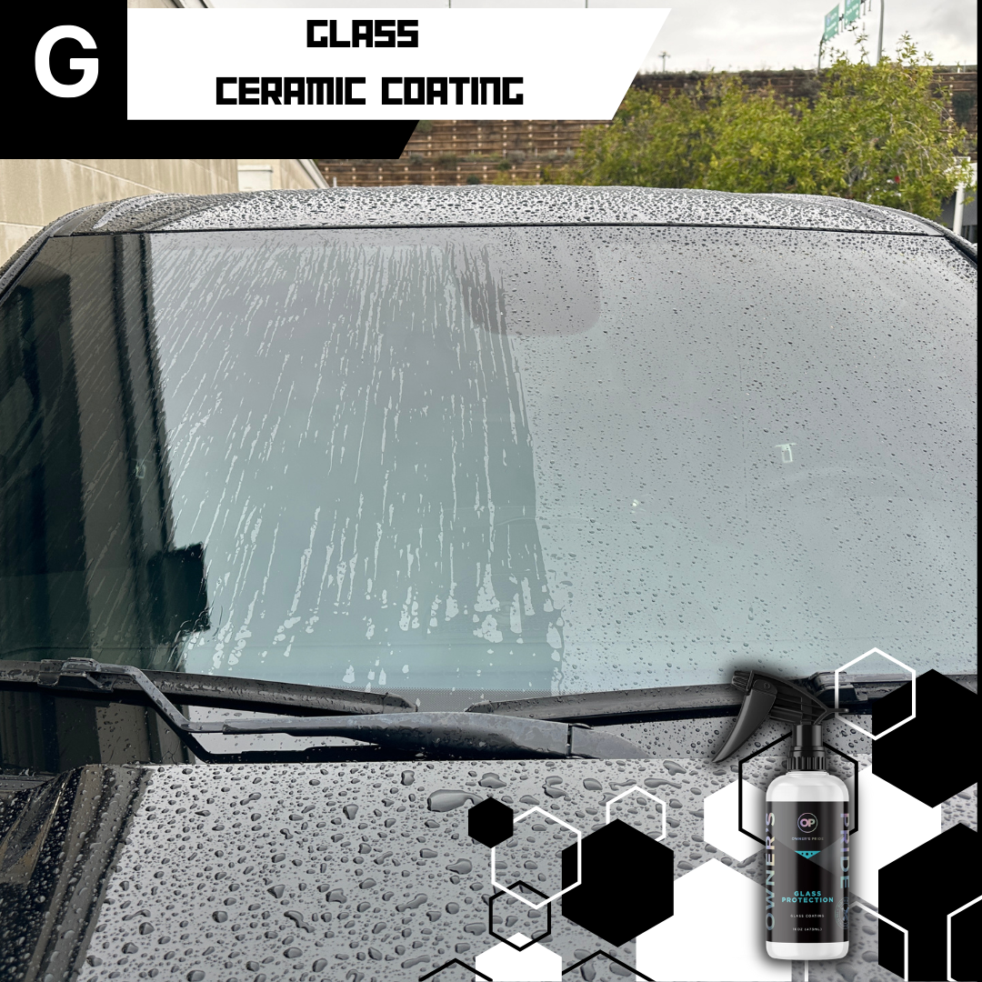 A black car's windshield with water beading, treated with ceramic coating. A spray bottle sits at the bottom.