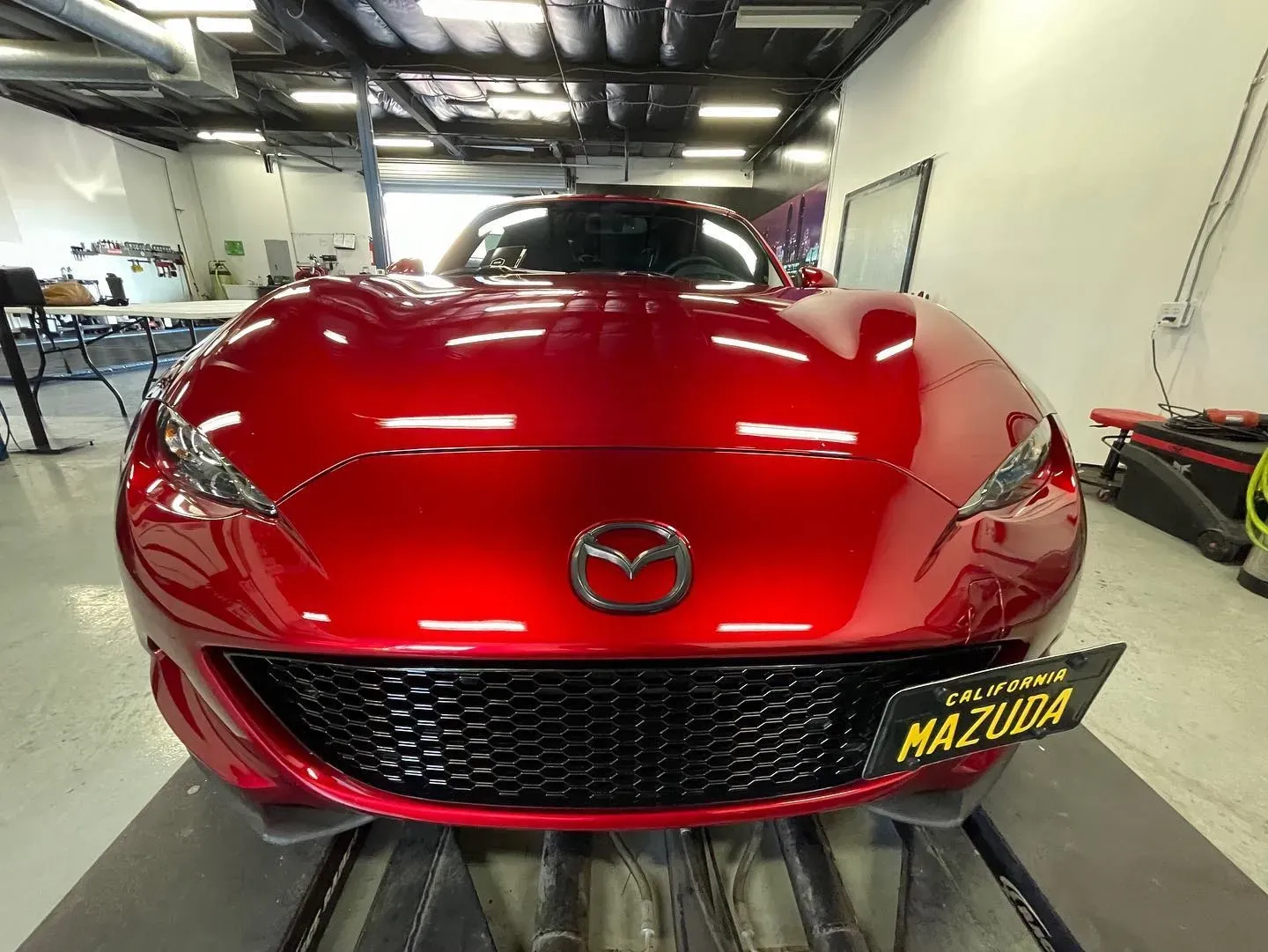 Close-up of clear paint protection film on red sports car for scratch resistance