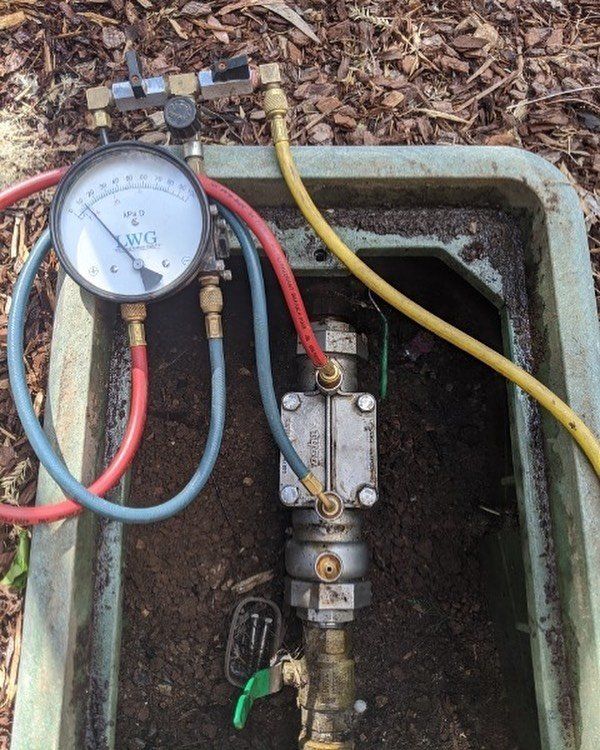 A hose with a gauge attached to it is connected to a valve