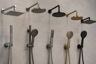 Display of assorted showerheads and hand showers in silver, black, and gold on a wall.