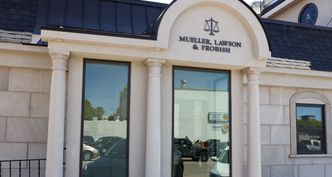 Law office exterior with columns, large windows, and sign: Mueller, Lawson & Frohlich.