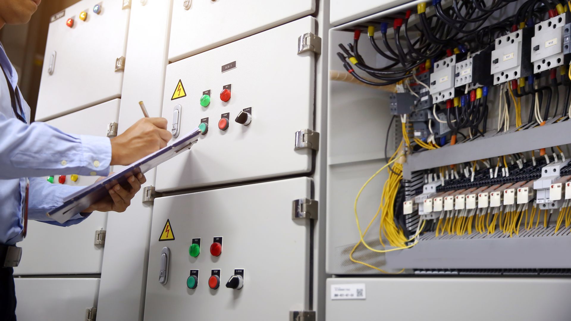 Professional performing NETA certified electric maintenance at circuit breaker terminal.