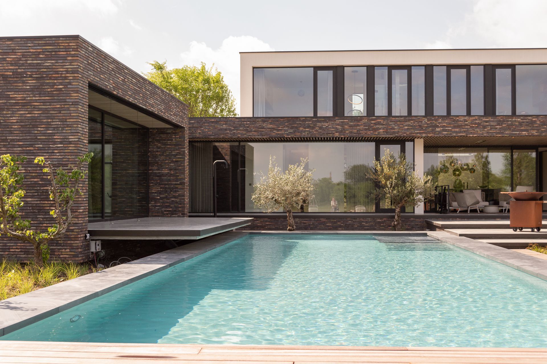 Een groot huis met een groot zwembad ervoor.