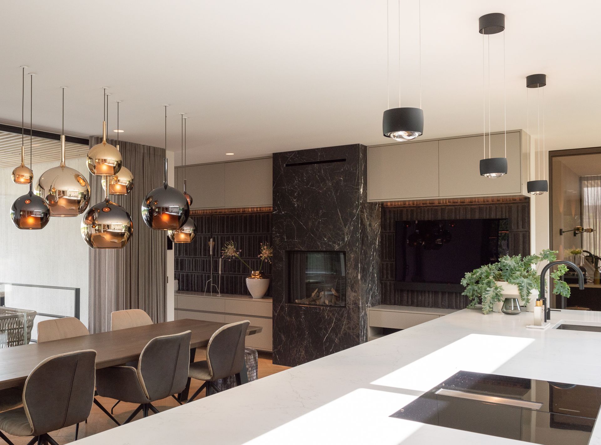 Een eetkamer met een tafel, stoelen van Mobitec en een open haard