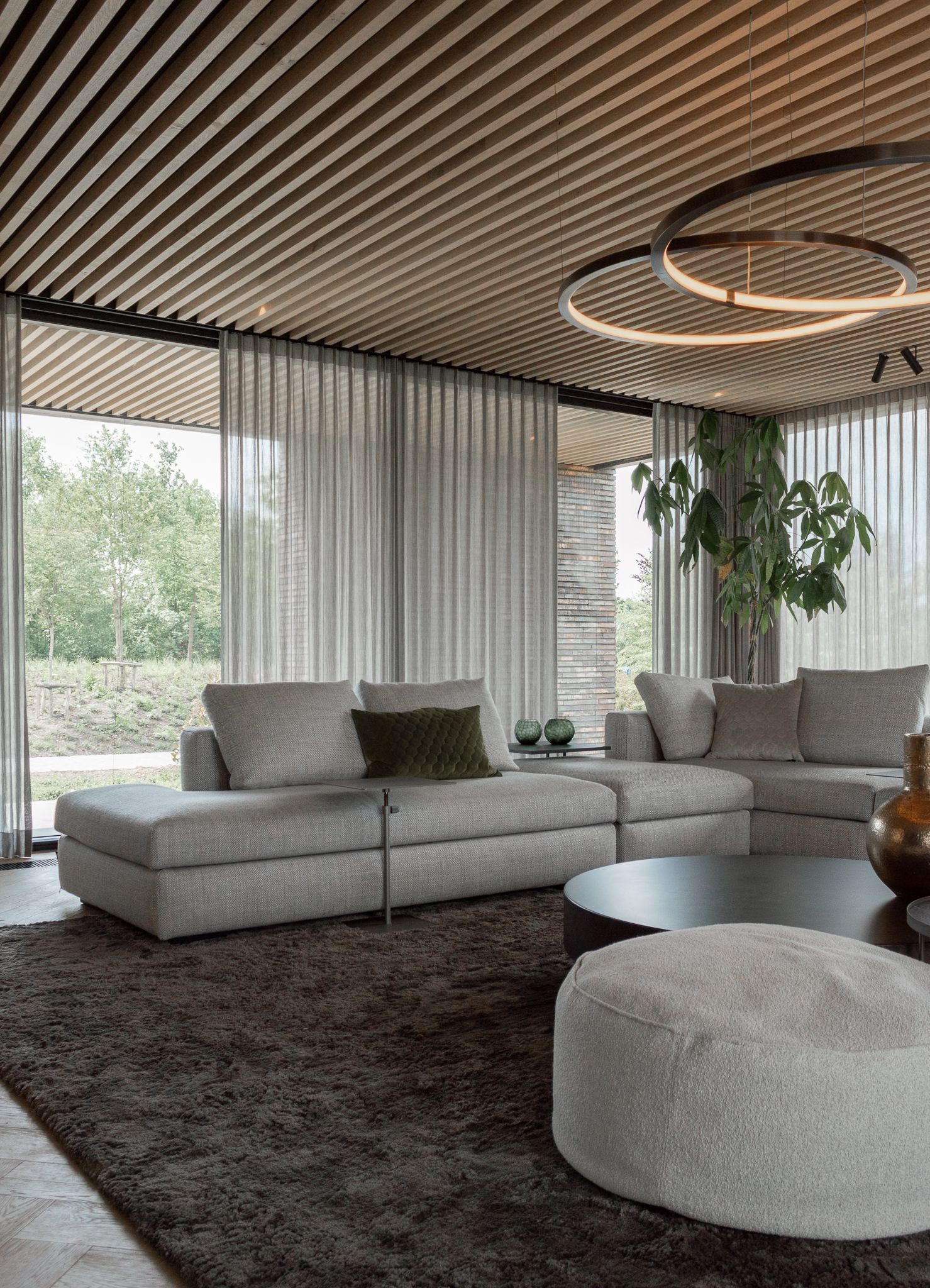 Een woonkamer met een bank Sur&Plus, salontafel van Cattelan Italia en tapijt.