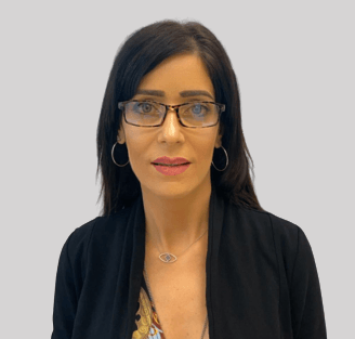 אישה עונדת משקפיים ועגילי חישוק מביטה במצלמה