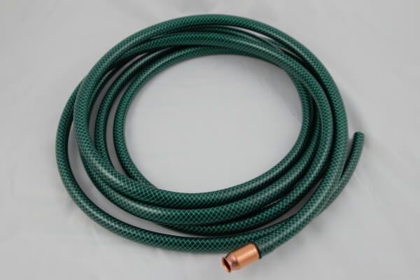 A coiled dark green garden hose with a metallic copper-colored nozzle at one end against a light gray background.
