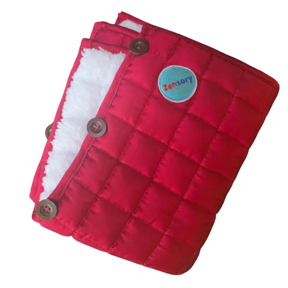 A grey, quilted sensory blanket with a soft white lining and brown button closures, featuring a blue circular logo.