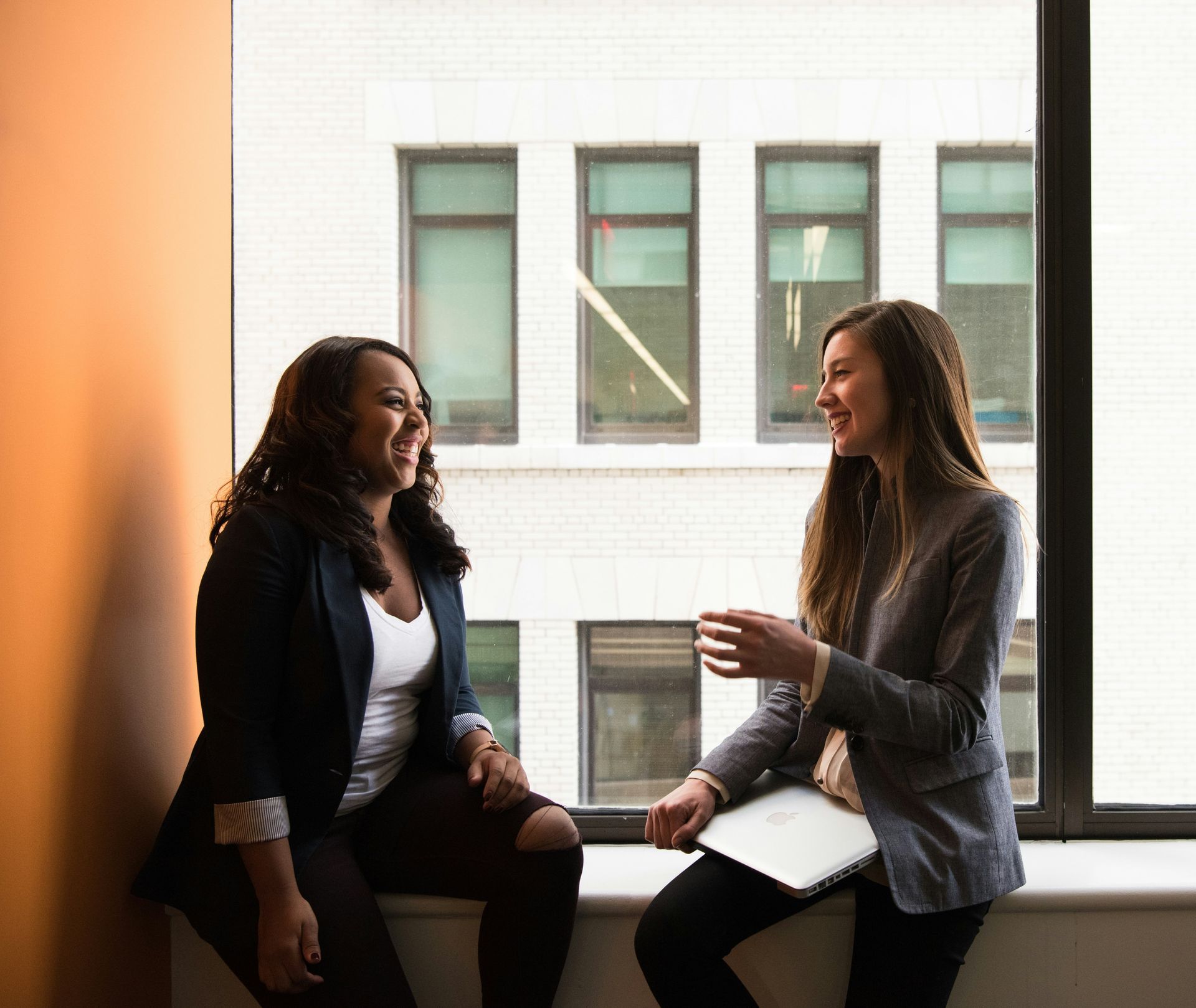 Two women sitting together talking.