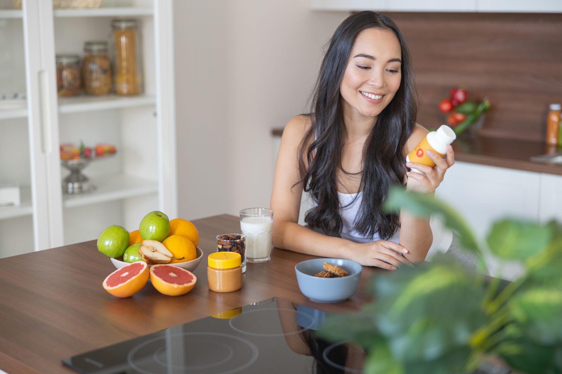 A woman is taking a supplement with her breakfast. A woman is taking a supplement with her breakfast.