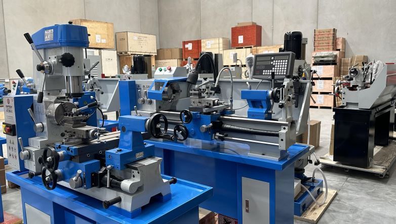 Blue metalworking machines in a workshop, including a lathe and milling equipment.