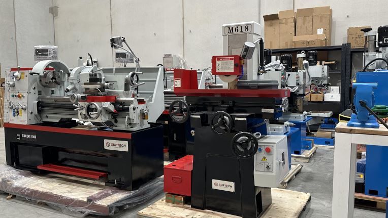 Industrial workshop with several metal lathes and machine tools on pallets and benches.