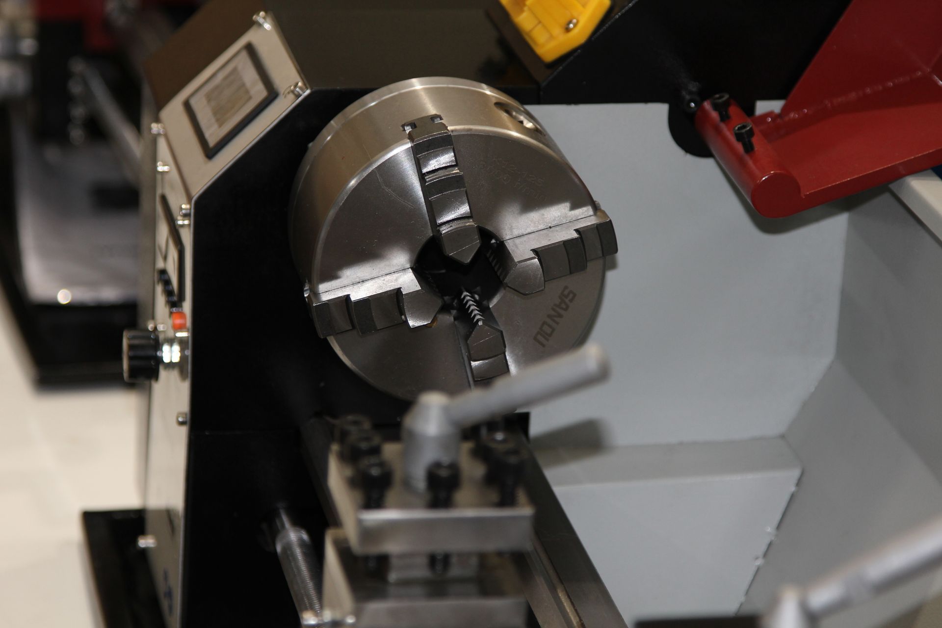 Close-up of a metal lathe chuck holding a workpiece in a workshop
