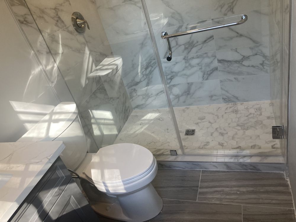 A bathroom with a toilet and a walk in shower.
