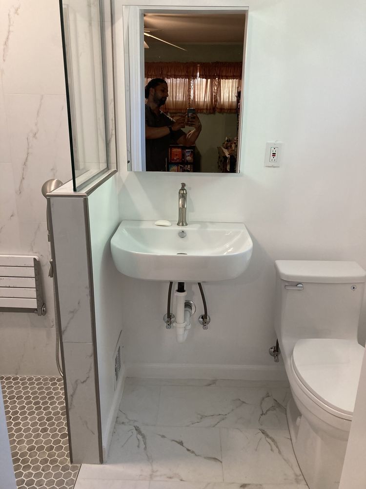 A bathroom with a sink , toilet and mirror.