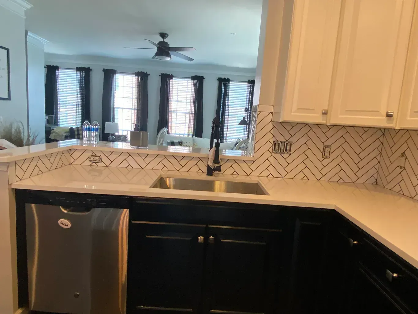 A kitchen with two sinks , a dishwasher , and a ceiling fan.